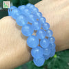 A bracelet made of light blue chalcedony beads worn on a wrist.