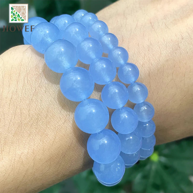 A bracelet made of light blue chalcedony beads worn on a wrist.