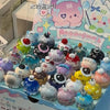 A collection of cute mini bean blind box figurines featuring various shapes and colors like strawberry mousse towers and octo