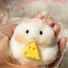A white silicone hamster fidget toy with a yellow triangle attached, held in a hand.