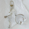 Silver beaded wing cross phone lanyard keychain attached to a clear phone ring.