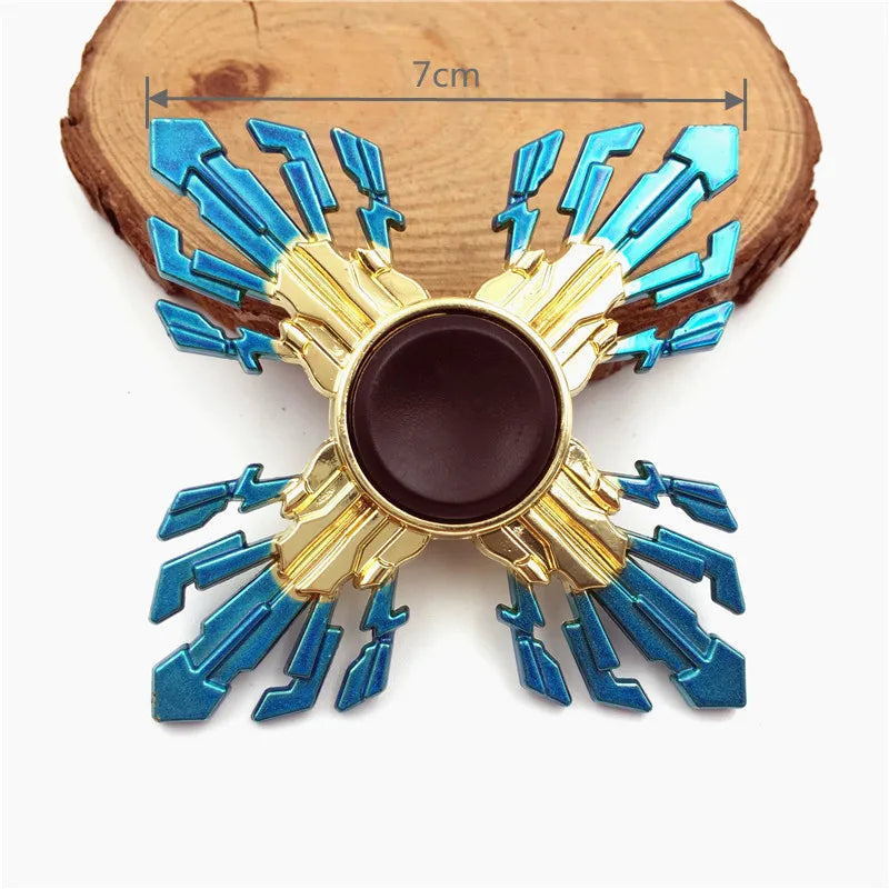 Metal fidget spinner with blue and gold rainbow finish mounted on a wooden block