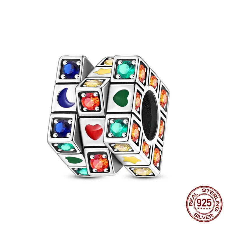 A collection of colorful, faceted gemstones set in silver cubes forming a rotatable Rubik's cube charm.