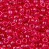 A close-up view of numerous small, translucent pink and red pony beads for jewelry making and crafts.