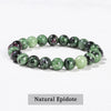 A bracelet made of natural epidote beads in various shades of green and pink.