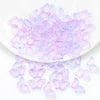 A pile of translucent purple and pink butterfly glass beads for jewelry making