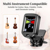 A black clip-on tuner with a color display is shown next to various stringed instruments like guitars and violins.