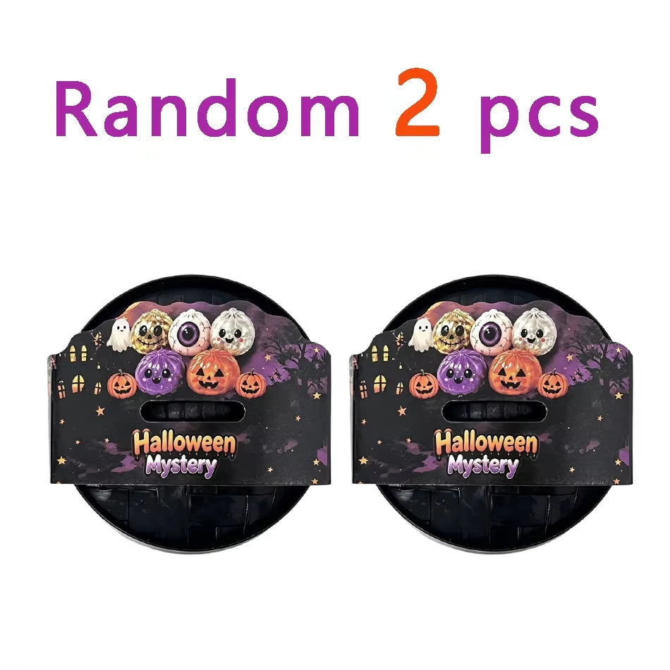 Two black containers of Halloween mystery squishy fidget toys including glitter pumpkin, eyeball, and skull stress relief bal