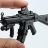 A black 1:6 scale MP5SD5 submachine gun model kit is held by a hand against a white background.