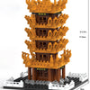 A detailed model kit of the Yellow Crane Tower built from orange and brown micro building blocks on a black base.