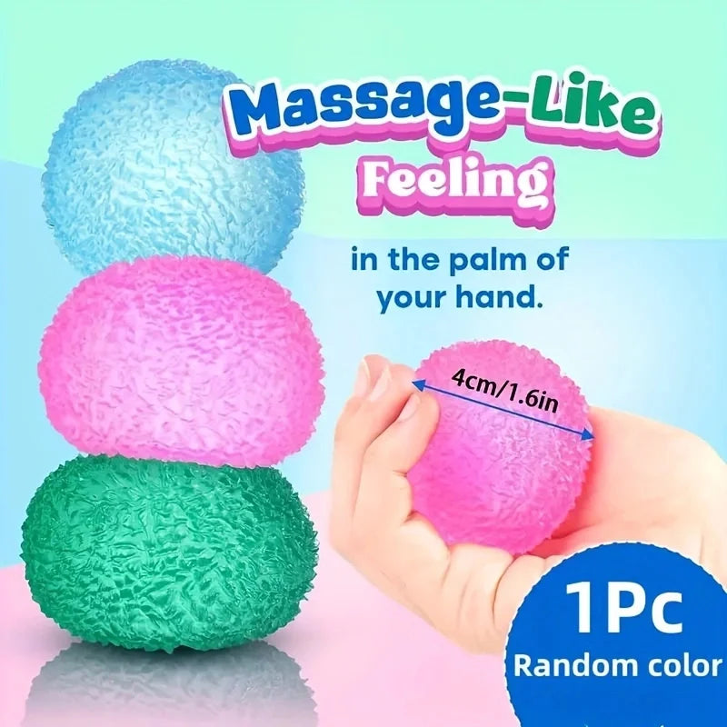 Eine Hand hält eine pinke, massageartige, weiche Eis-Kugel mit blauem und grünem Hintergrund.