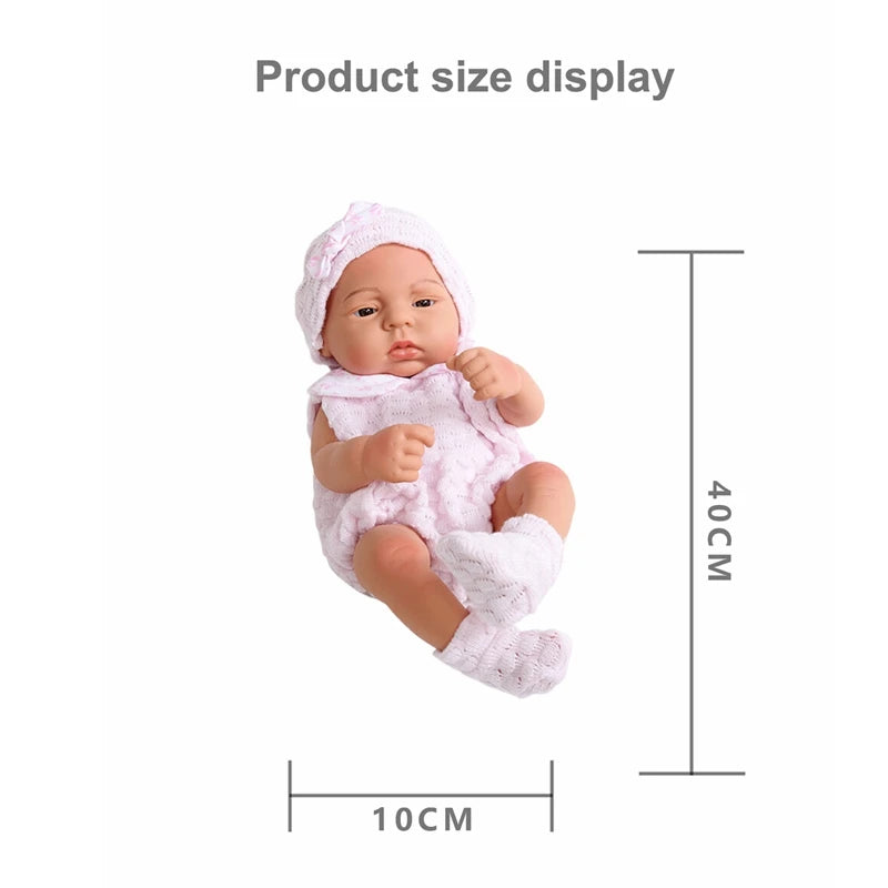 A pink vinyl reborn doll with an outfit is displayed next to a measurement scale.