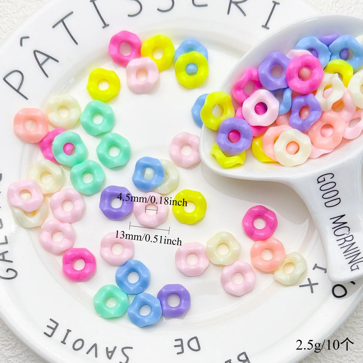 A variety of pastel wavy acrylic beads in pink, yellow, purple, and green are displayed on a white plate.