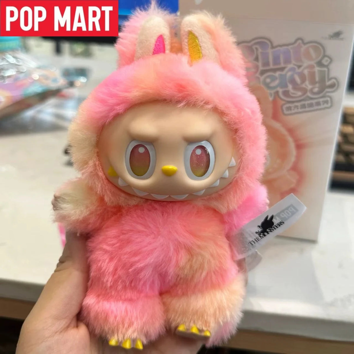 A pink Labubu 3.0 Big Into Energy collectible plush doll with fluffy pink fur and yellow accents.