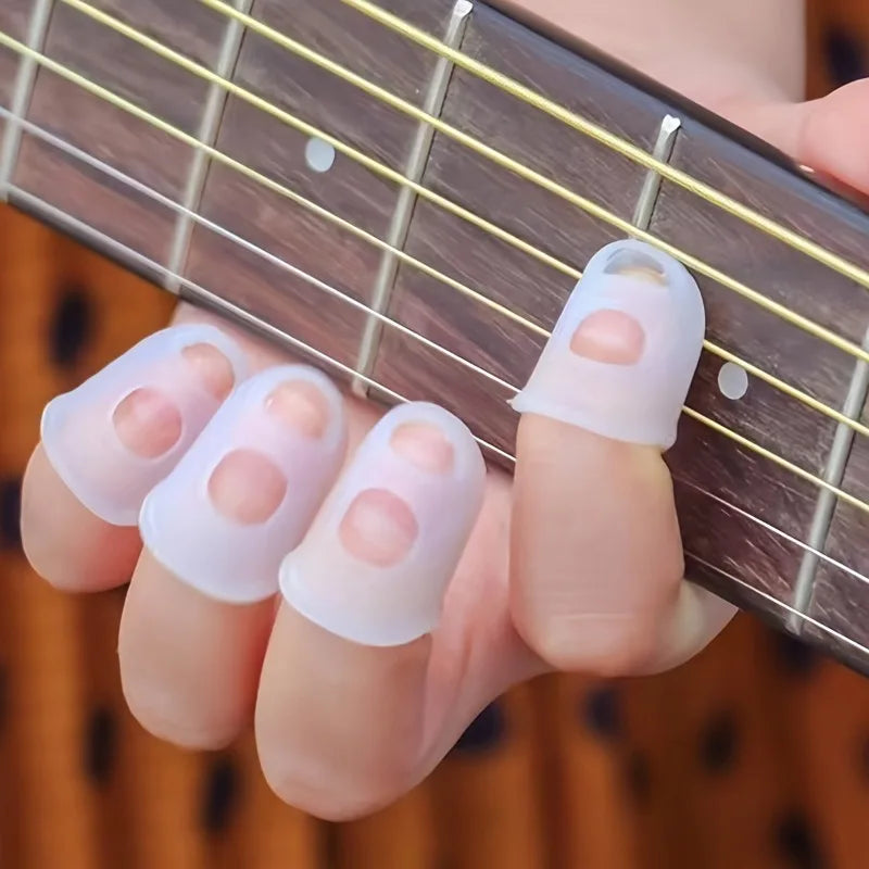 A hand wearing white silicone guitar finger sleeves on a wooden guitar fretboard.
