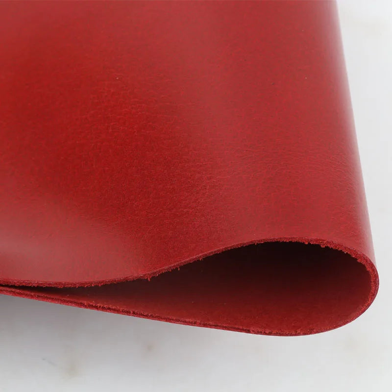 A sheet of wine red oil wax leather used for DIY craft projects, rolled and shown in profile.