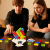 Two children are playing with a colorful balance stacking tower game on a dark table.