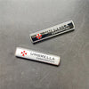 Two silver metal badges featuring the Umbrella Corporation logo and name on a dark gray surface.