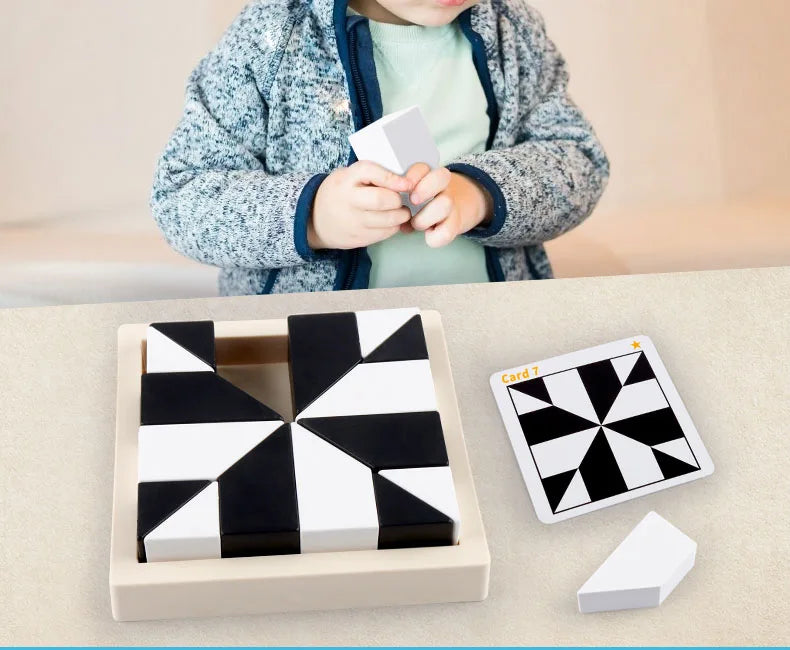 A child holds a white geometric block puzzle piece, with the assembled pieces and an extra piece displayed next to a light be