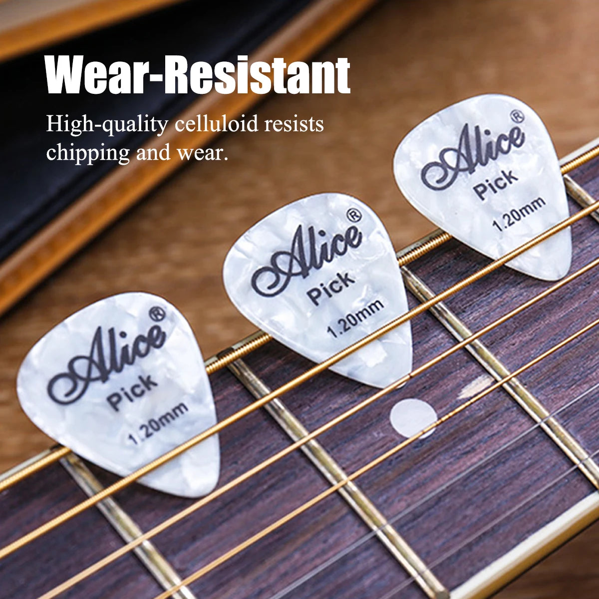 Close-up of white celluloid guitar picks on a wooden fretboard with gold strings.