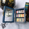 A handcrafted wooden miniature bookshelf ornament featuring a dark blue frame and multiple small books.