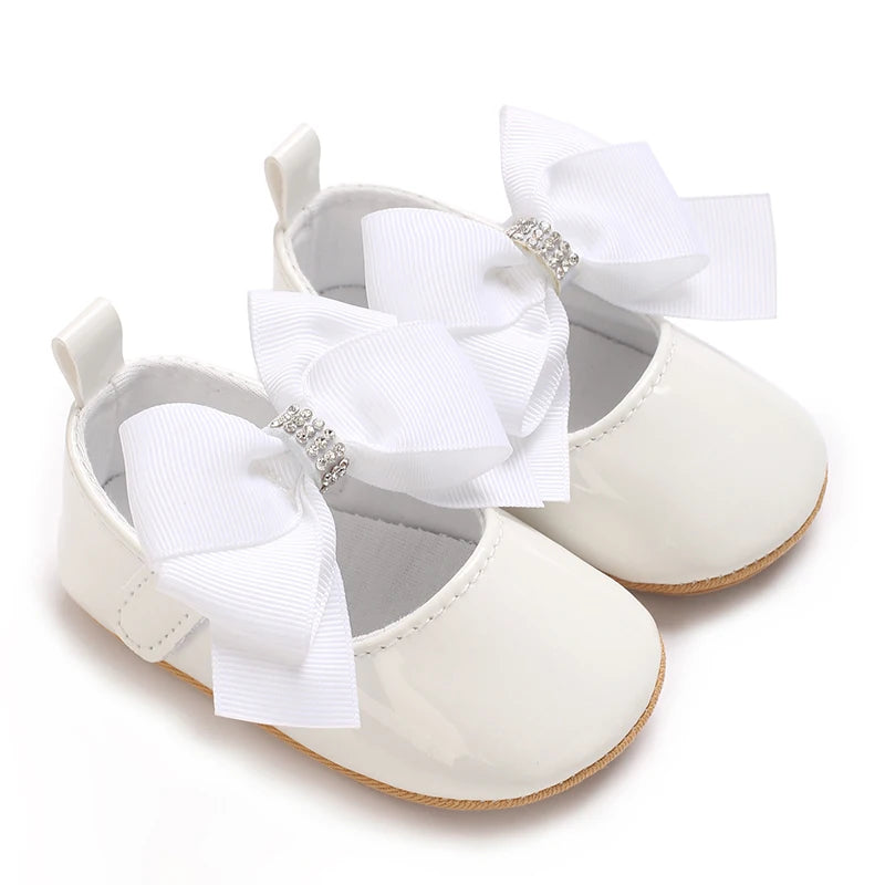 White lace-trimmed baby girl moccasin shoes with a white bow