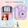 A pink instant color printing camera with a built-in screen and a lens, along with thermal paper and a USB data cable.