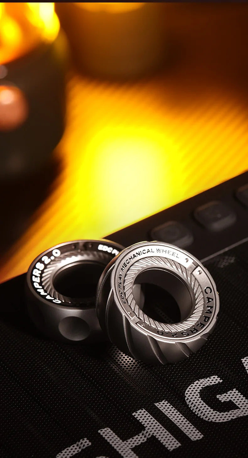 A close-up of a silver magnetic fidget ring with an adjustable wheel resting on a dark surface.