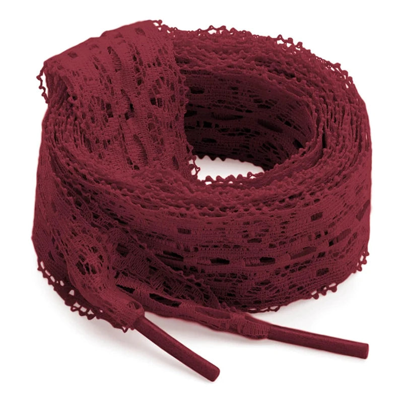 A spool of deep red flat elastic silk lace shoelaces coiled on a white background.