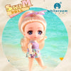 A light pink doll with blonde hair wearing a purple top and skirt, posed in a water setting.