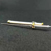 A samurai sword keychain featuring a white blade and gold accents resting on a dark surface.