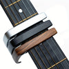 A close-up view of an aluminum alloy quick-change guitar capo with a dark wood body and silver accents.