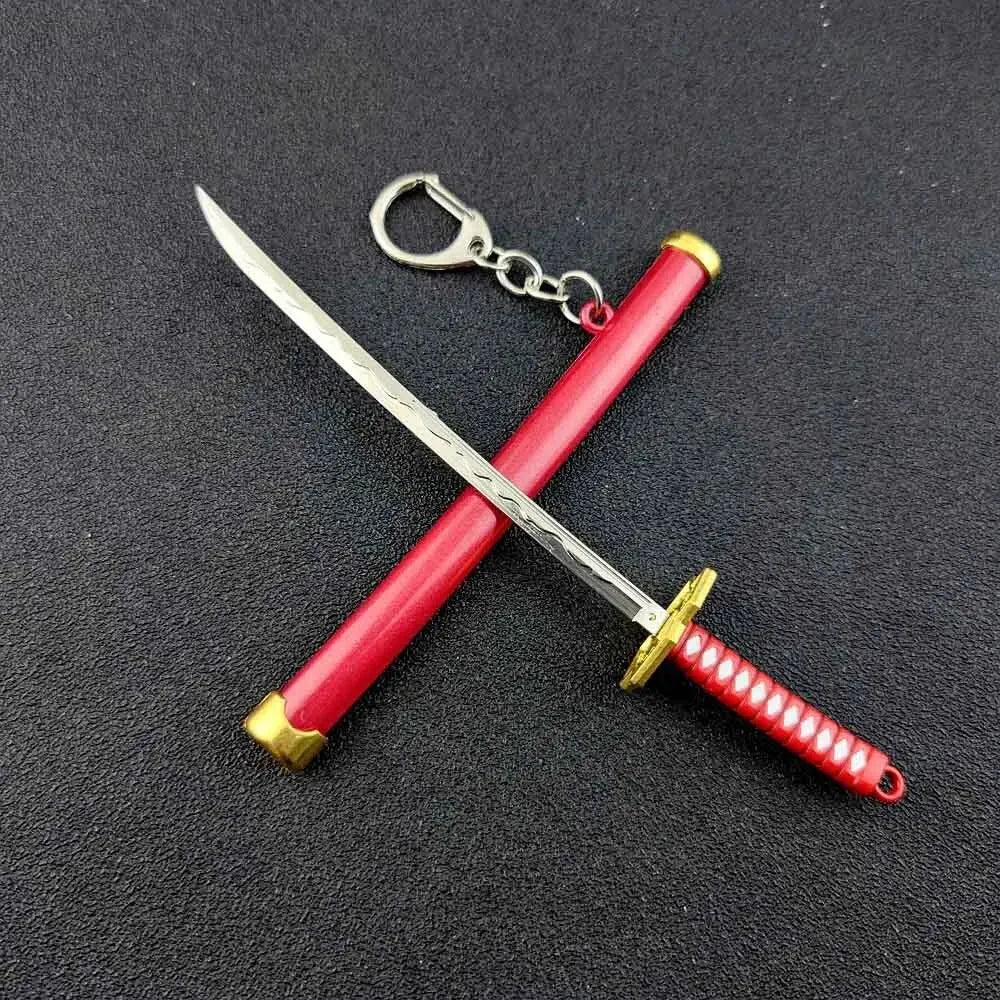 A samurai sword keychain with a silver blade and red hilt, displayed against a dark background.