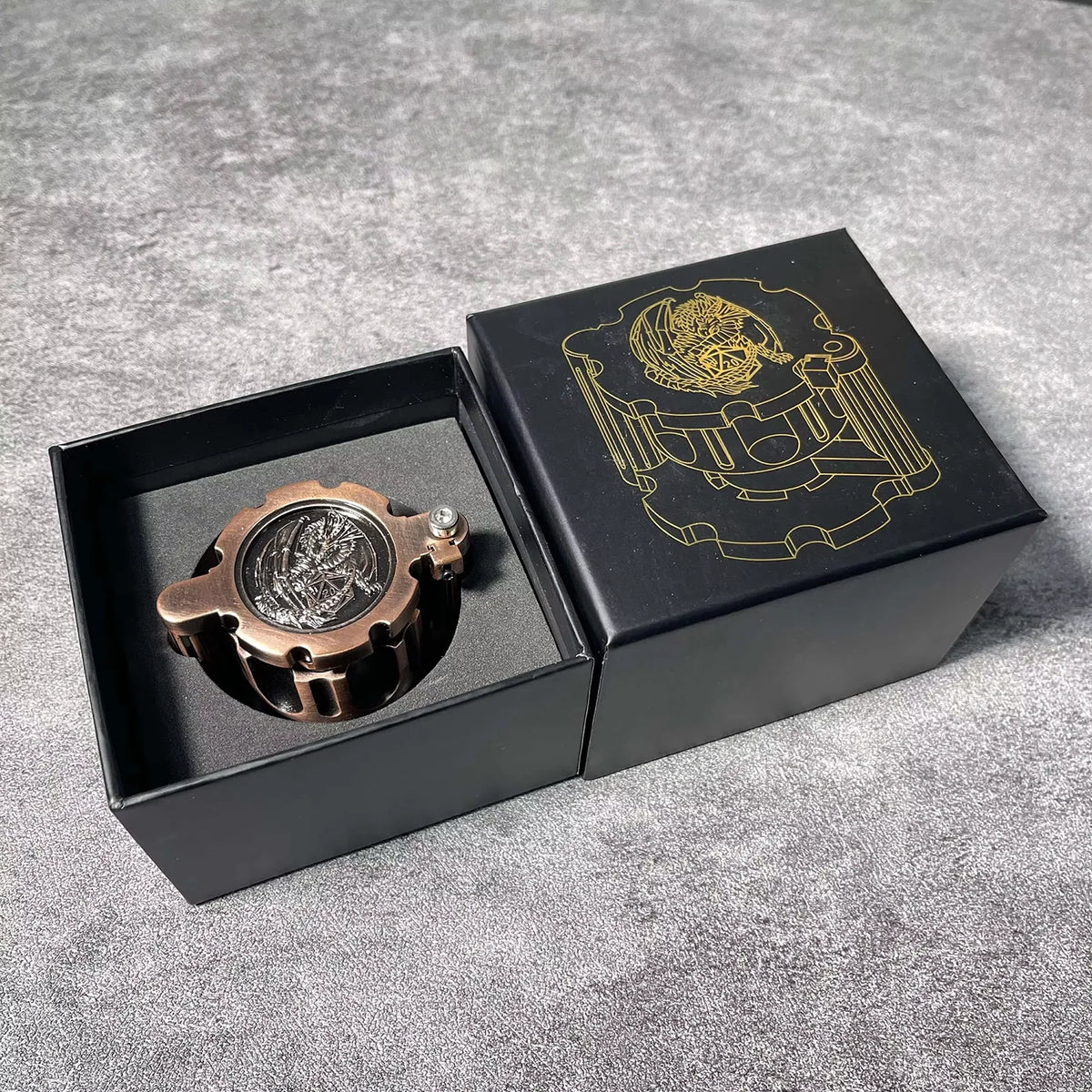 Una caja negra con un juego de dados poliedrales de bronce e ilustración dorada de un emblema en la tapa.