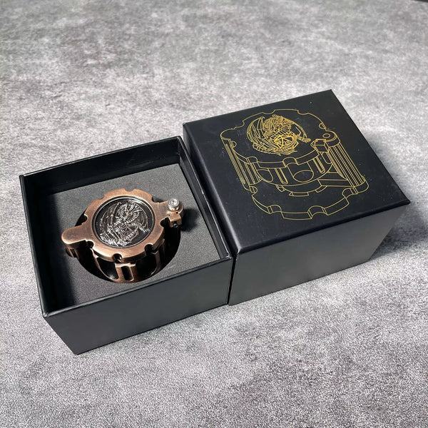 A black box containing a bronze polyhedral dice set and a gold-line illustration of an emblem on the lid.