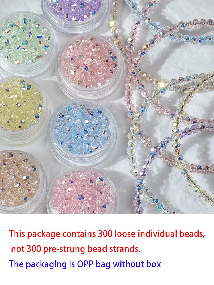 A collection of 300 loose individual glass beads in various colors including pink, blue, and gold scattered on a white surfac