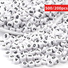 A pile of small white acrylic number beads, including 0 through 9, for DIY jewelry making.