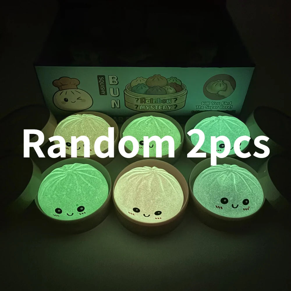 A collection of two glowing green soft sensory squishy dumpling toys displayed in a box.