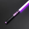 A purple lightsaber toy with a metal handle and illuminated blade resting on a dark surface.