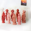 A collection of reddish-pink silicone figure molds for candle and resin crafting displayed on a white surface.