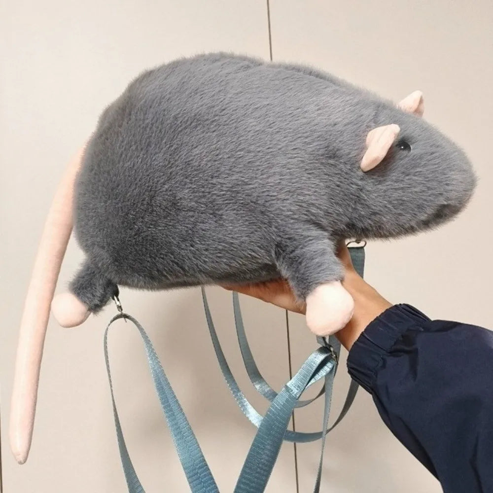 A gray mouse plush backpack is being held by a person's hand.