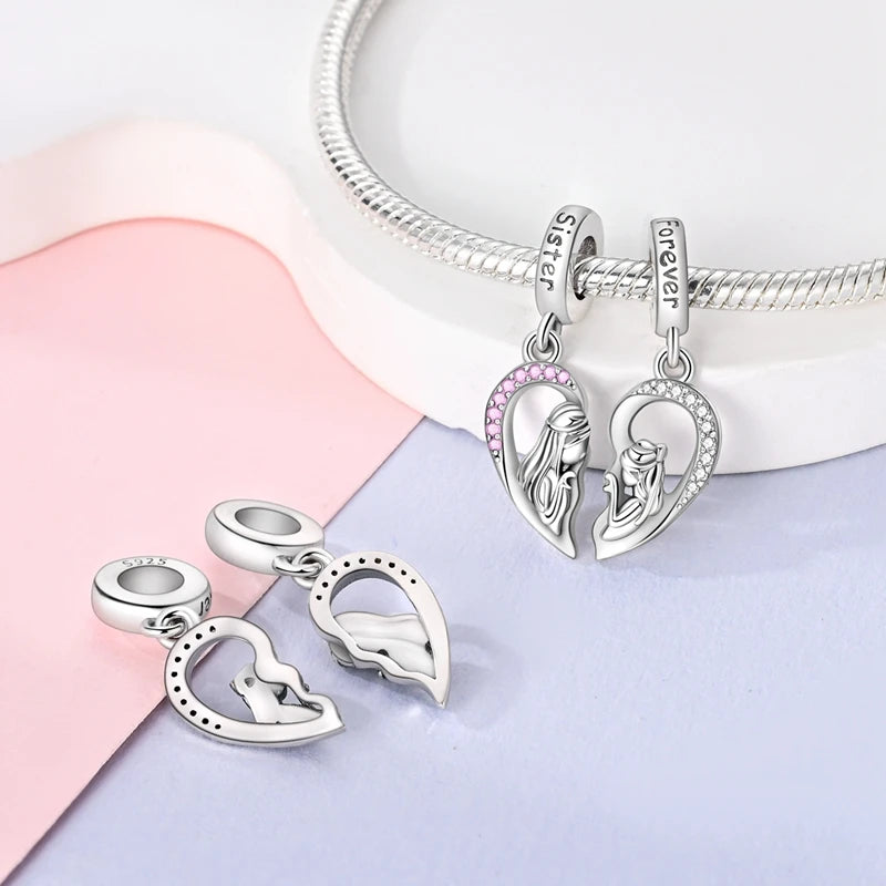 Silver heart charm pendant and hoop bracelet shown on a light pink background
