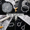 A collection of 300 crystal glass beads in various mixed shapes and sizes with an AB finish displayed on a black plate.