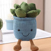 A cute, soft blue succulent plush toy with green leaves and brown legs sitting on a wooden surface.