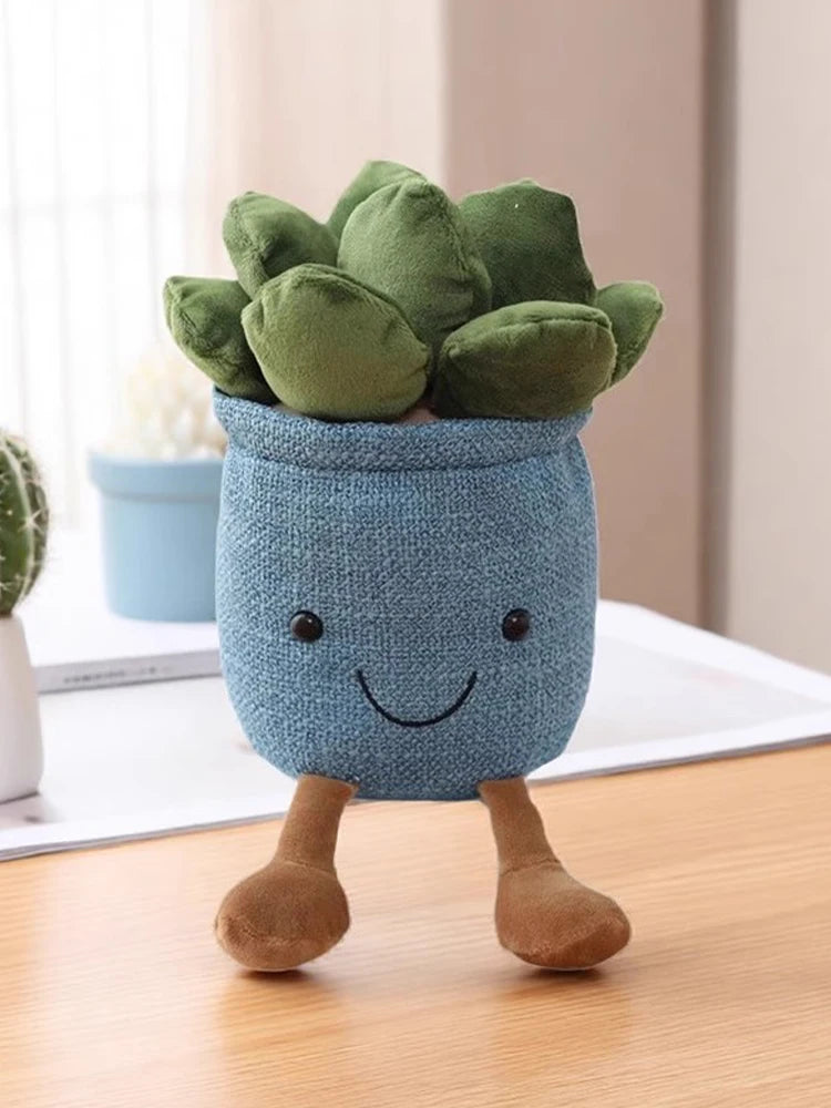 A cute, soft blue succulent plush toy with green leaves and brown legs sitting on a wooden surface.