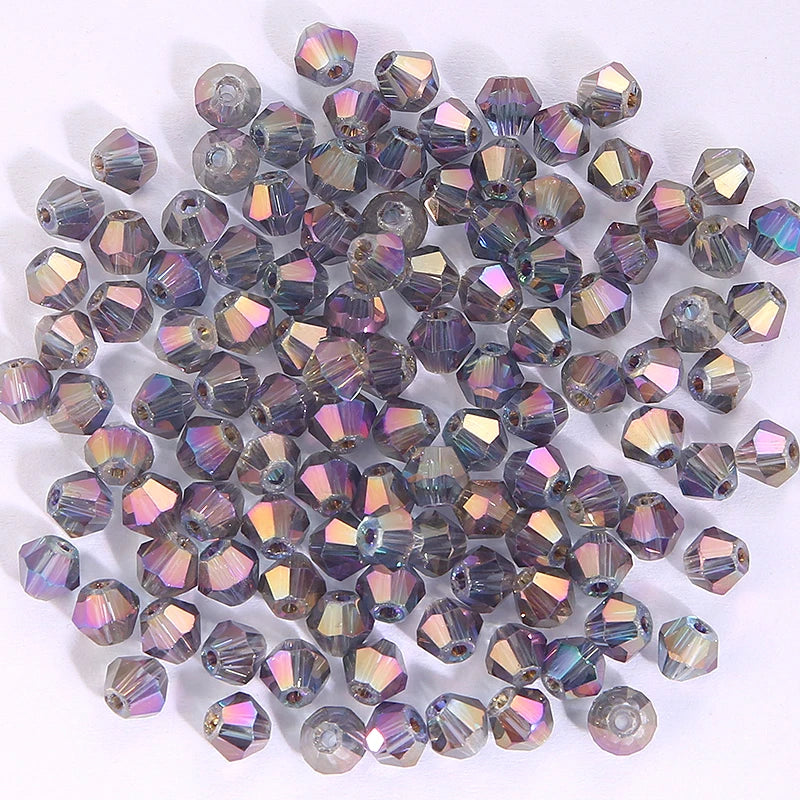 A collection of small, faceted crystal bicone glass beads in various shades of purple and blue.