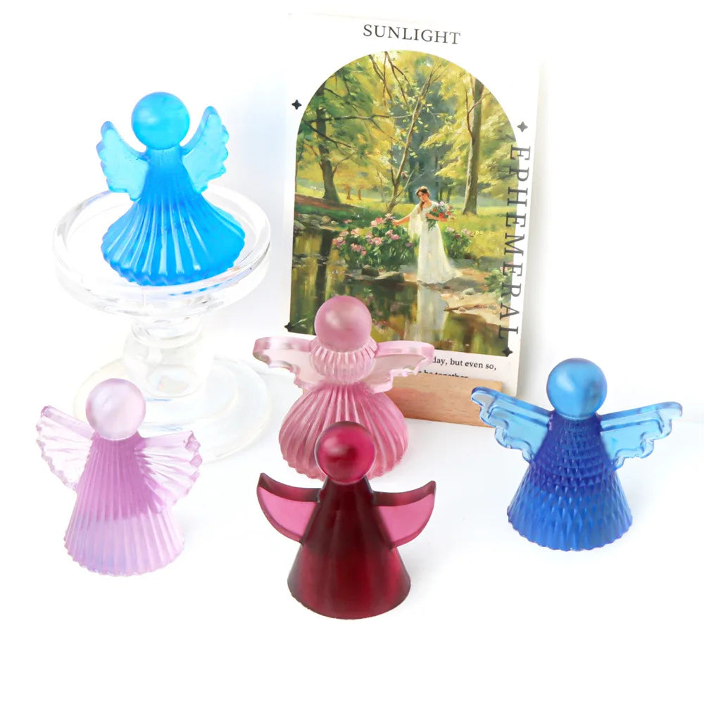 A set of silicone molds shaped like cherub angels in various shades of blue and pink for candles and soap making.