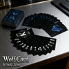 A stack of black Wolf Card playing cards is displayed on a gray surface.