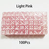 A pack of 100 light pink acrylic six-sided dice with transparent rounded edges.