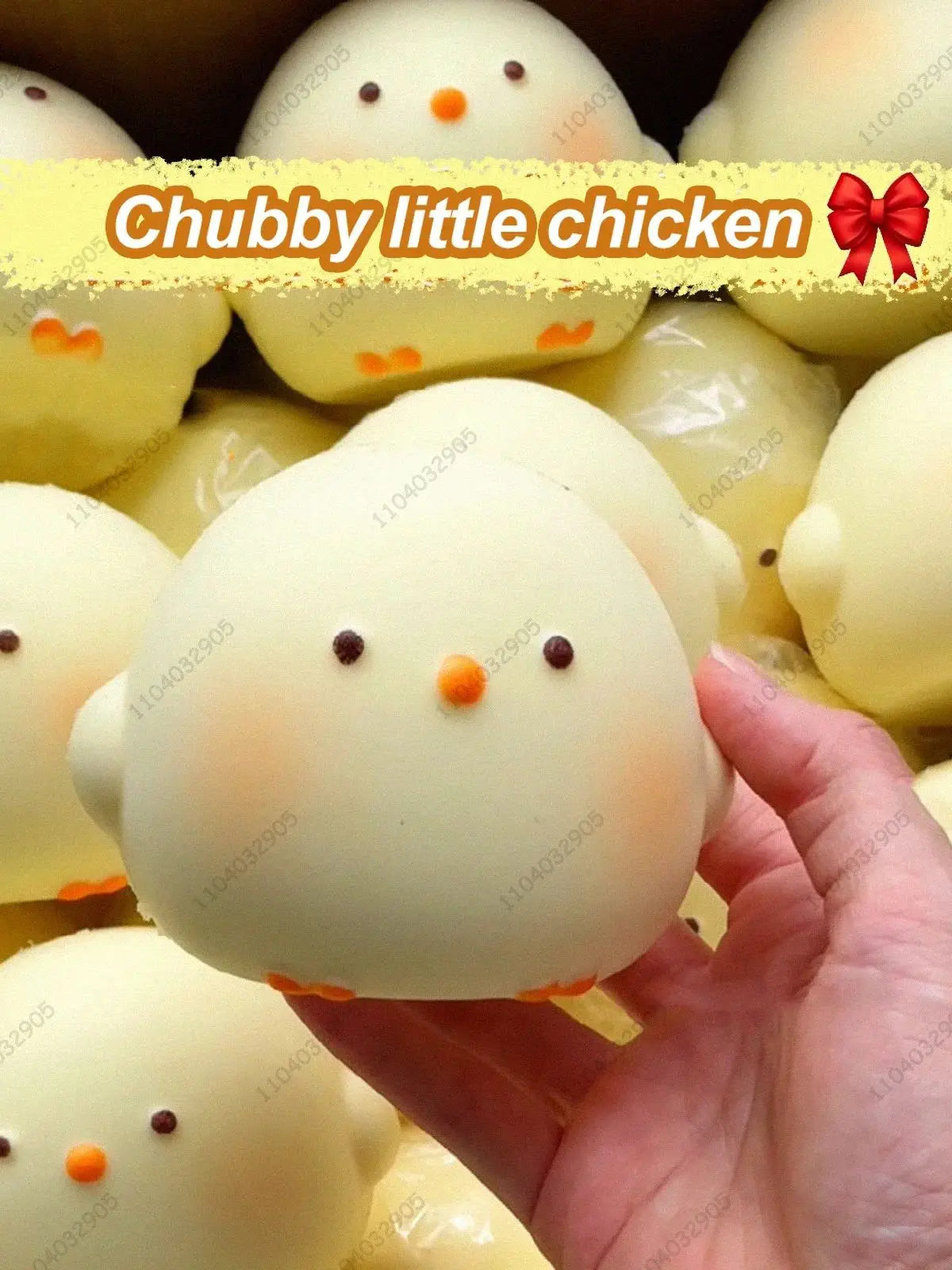 A hand holds a white chubby little chicken squishy toy with orange accents against a blurred background of similar toys.